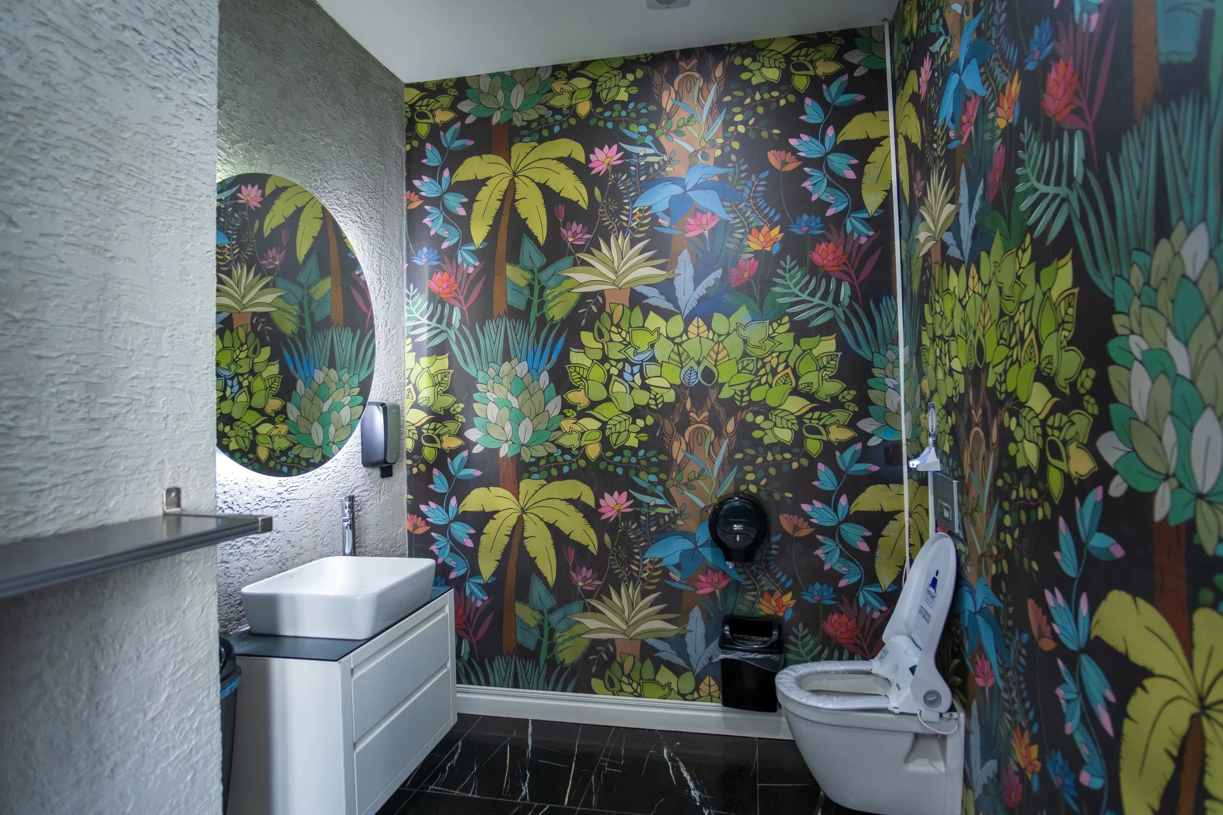 Sanitaire ruimte met junglebehang en hangend toilet