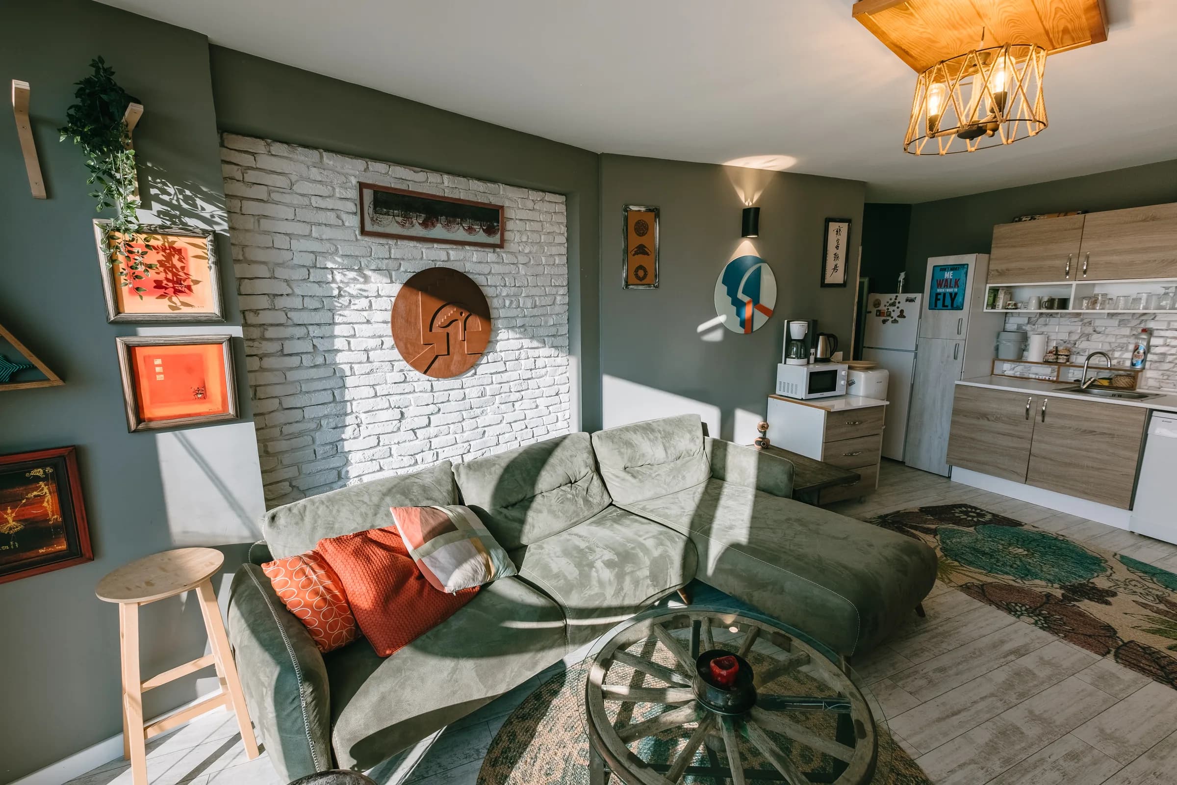 Woonkamer met groene bank en witte bakstenen wand