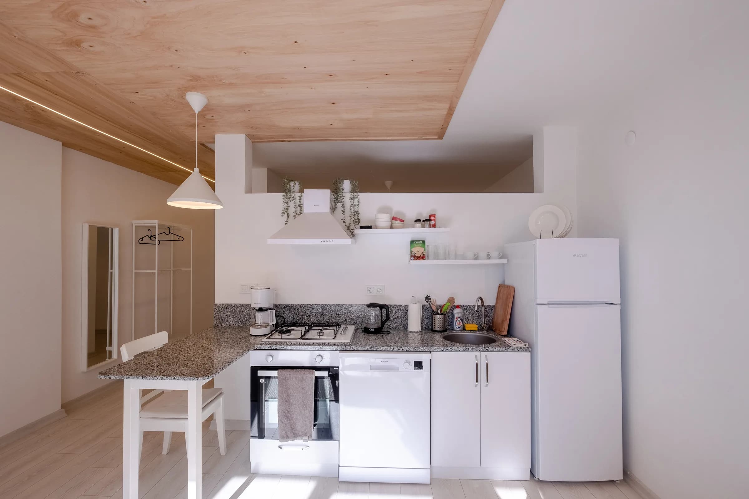 Keuken met witte fronten en houten plafond