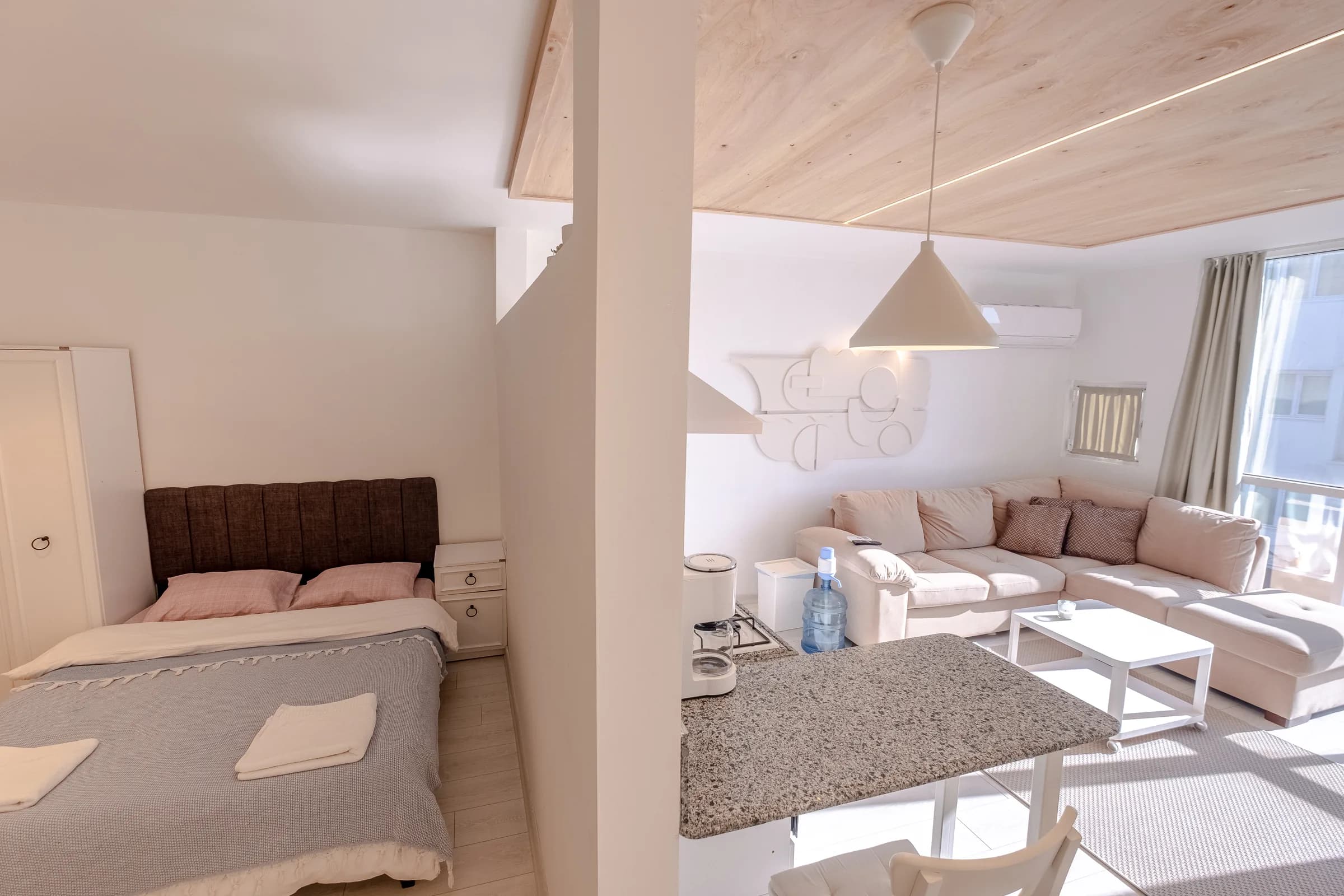 Slaapkamer en woonkamer, gescheiden door een halfhoge wand