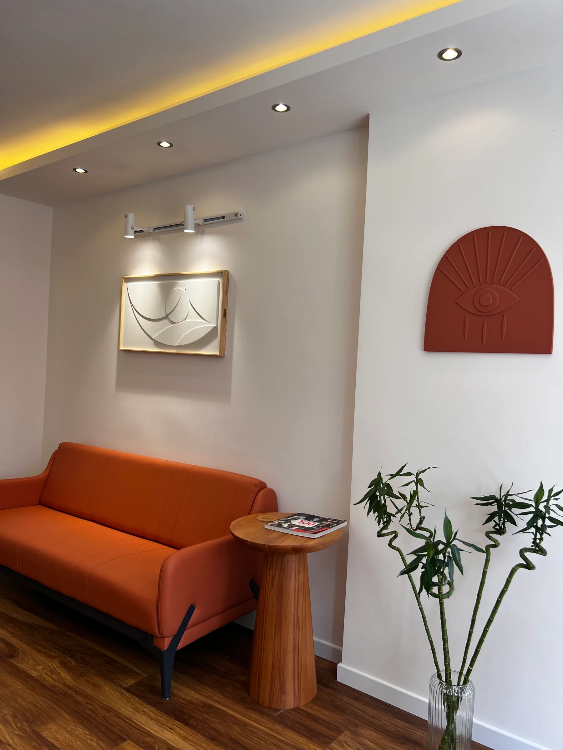 Zithoek met oranje bank en reliëfkunst