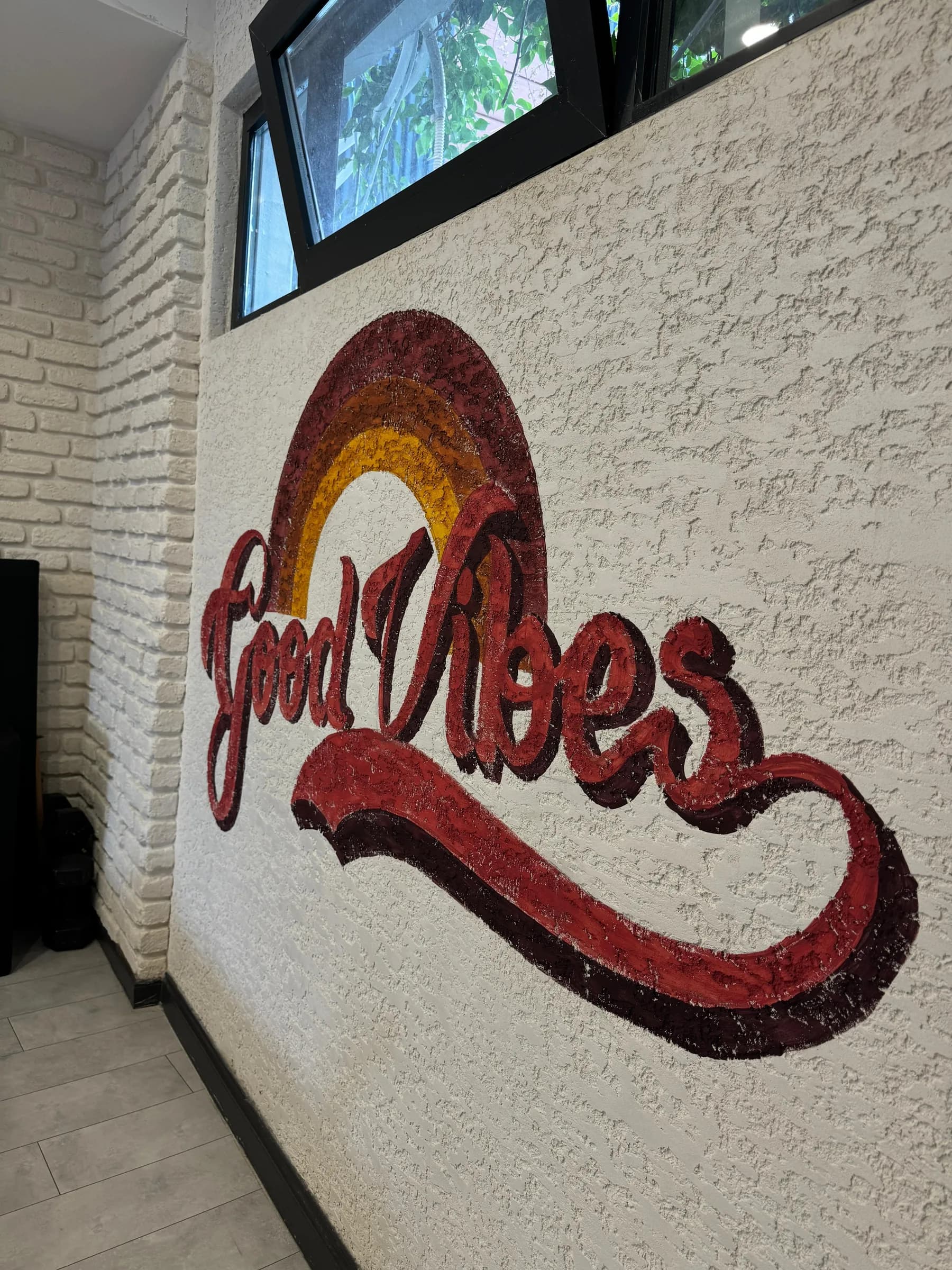 Wand met handgeschilderde belettering in rood en oker