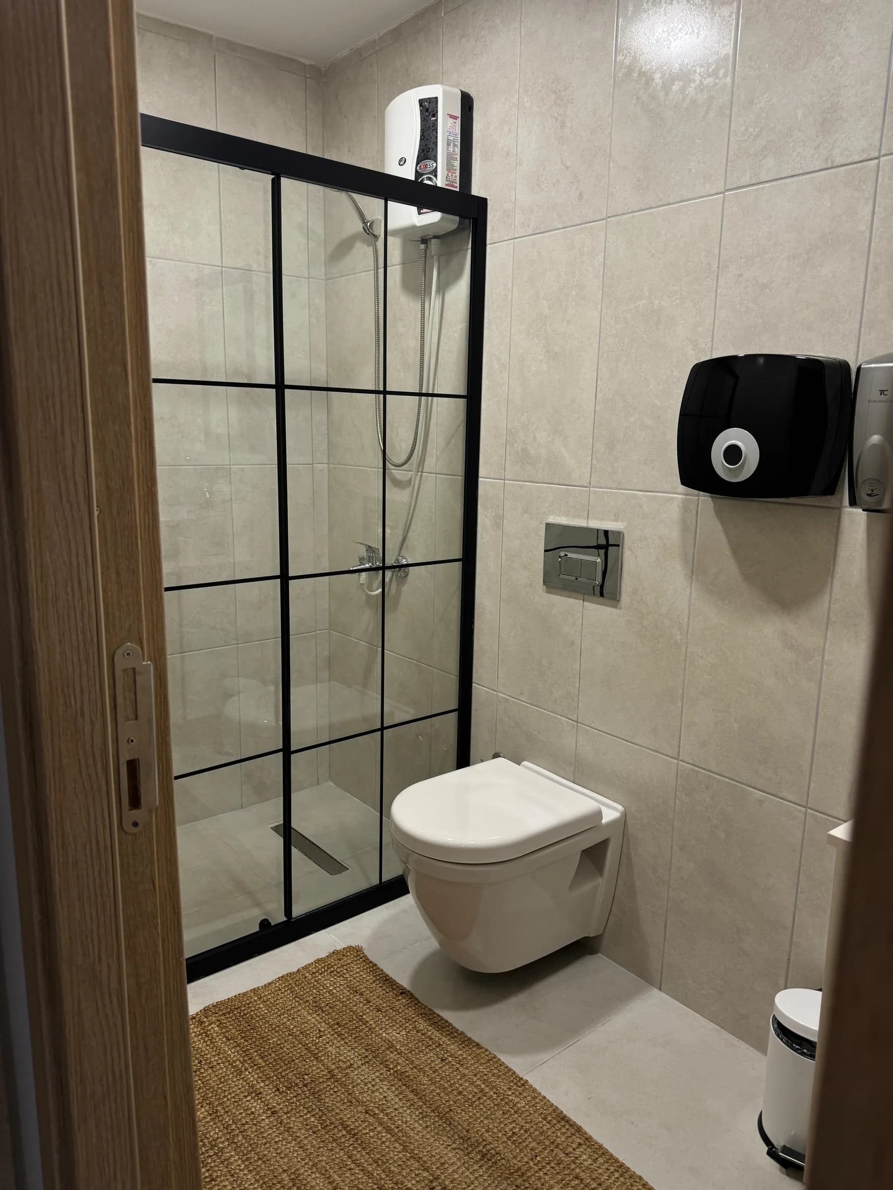 Doucheruimte met zwart omlijste glazen wand